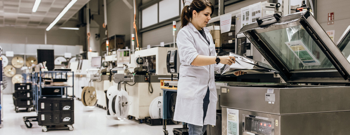 opératrice devant machine sous vide industrielle